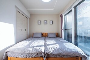 A bedroom with a double bed, a sliding door closet, and a large window with a view.