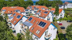 Un quartier résidentiel avec des maisons modernes dotées de toits inclinés et de panneaux solaires.