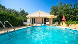 A swimming pool with a covered seating area and lounge chairs. - Relax near Corfu’s finest beaches in this charming villa for up to 4 guests (Halikounas)