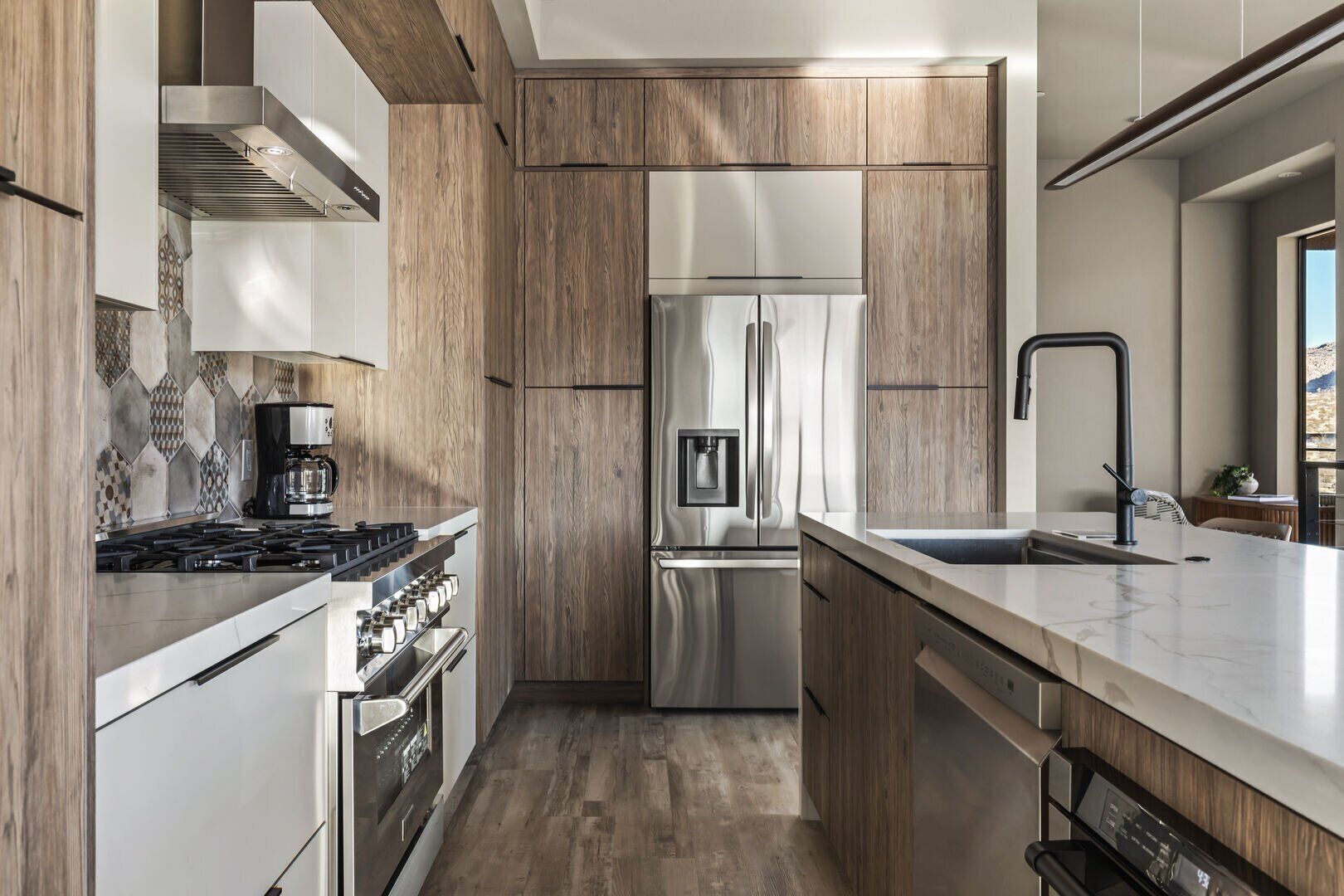 Una cocina moderna con estufa a gas, refrigerador de acero inoxidable y armarios de madera.