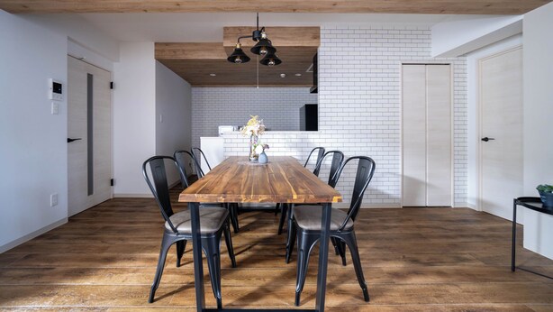 A dining area with a wooden table, black chairs, and a hanging light fixture. - ZABO HILLS 301 (Sapporo)