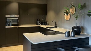 A modern kitchen with a central island, built-in appliances, and a minimalist design.