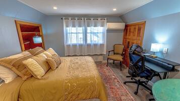 A bedroom with a bed, a desk, a chair, and a wardrobe.