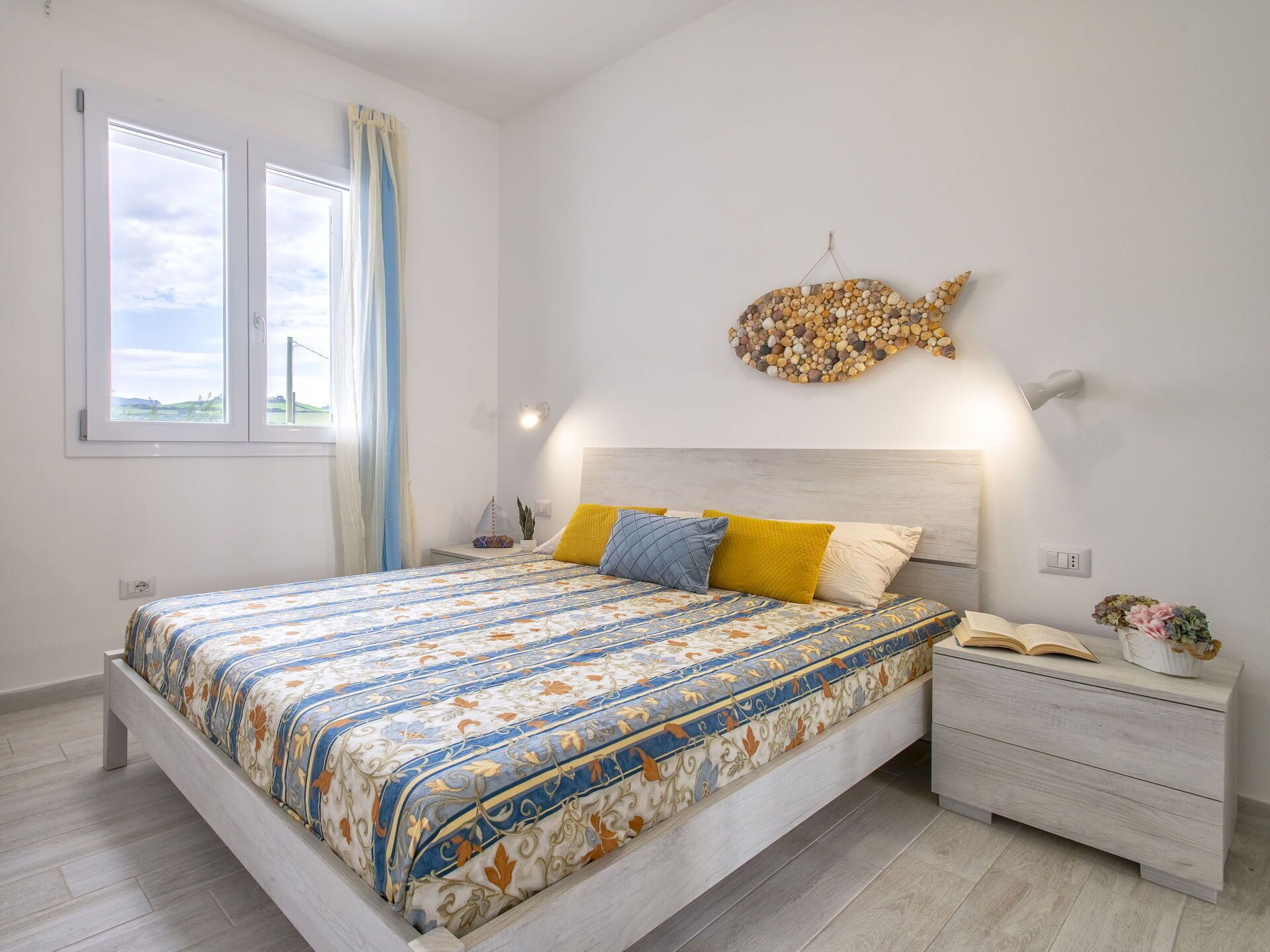 Un dormitorio con cama, mesita de noche y un adorno en la pared.