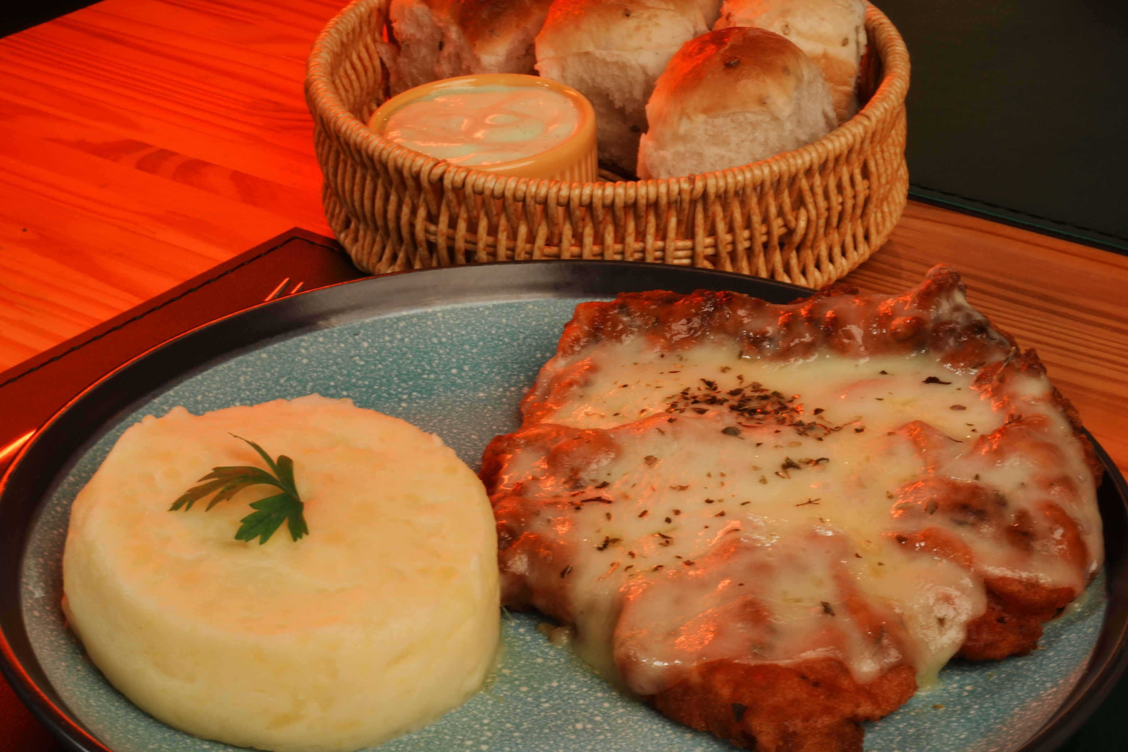 A plate with mashed potatoes and a meat dish, possibly chicken, garnished with herbs.