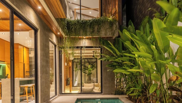 A modern house with a swimming pool, large windows, and a dining area. - Nanna Villa Unit 2 by Betterplace (Canggu)