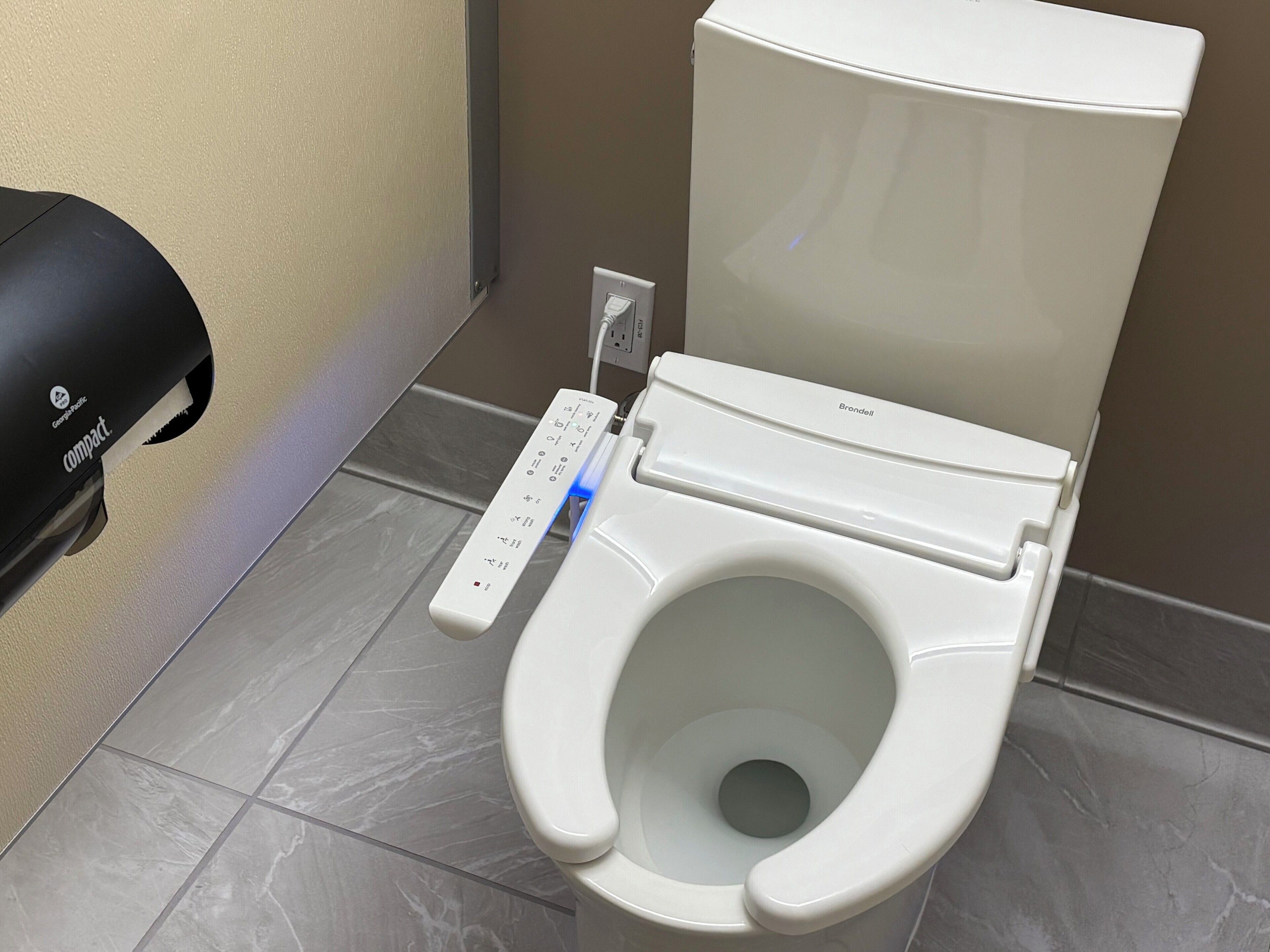 Un bagno moderno con pannello di controllo e un profumatore compatto.
