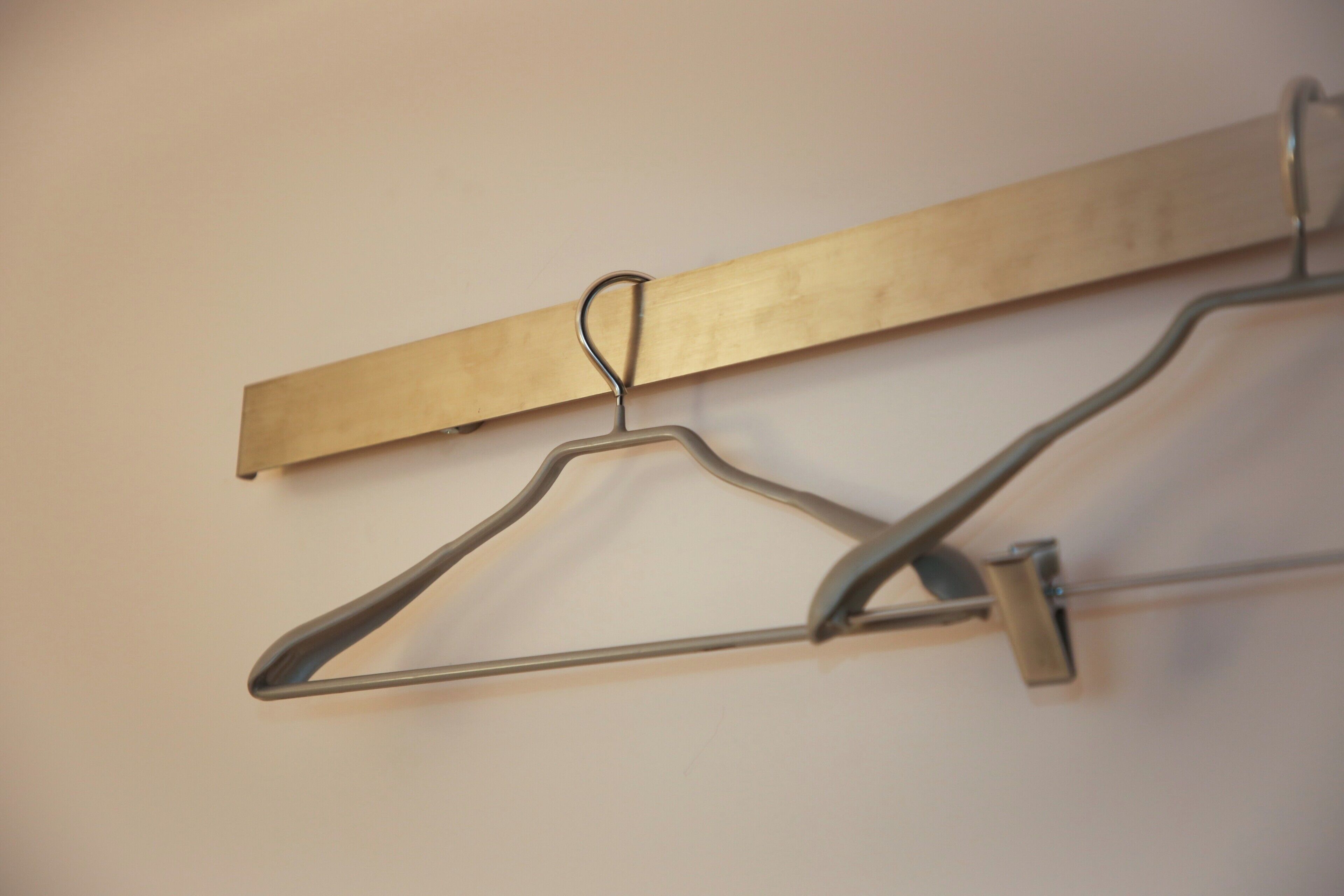 A wall-mounted metal hanger with a wooden board.
