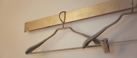 A wall-mounted metal hanger with a wooden board.