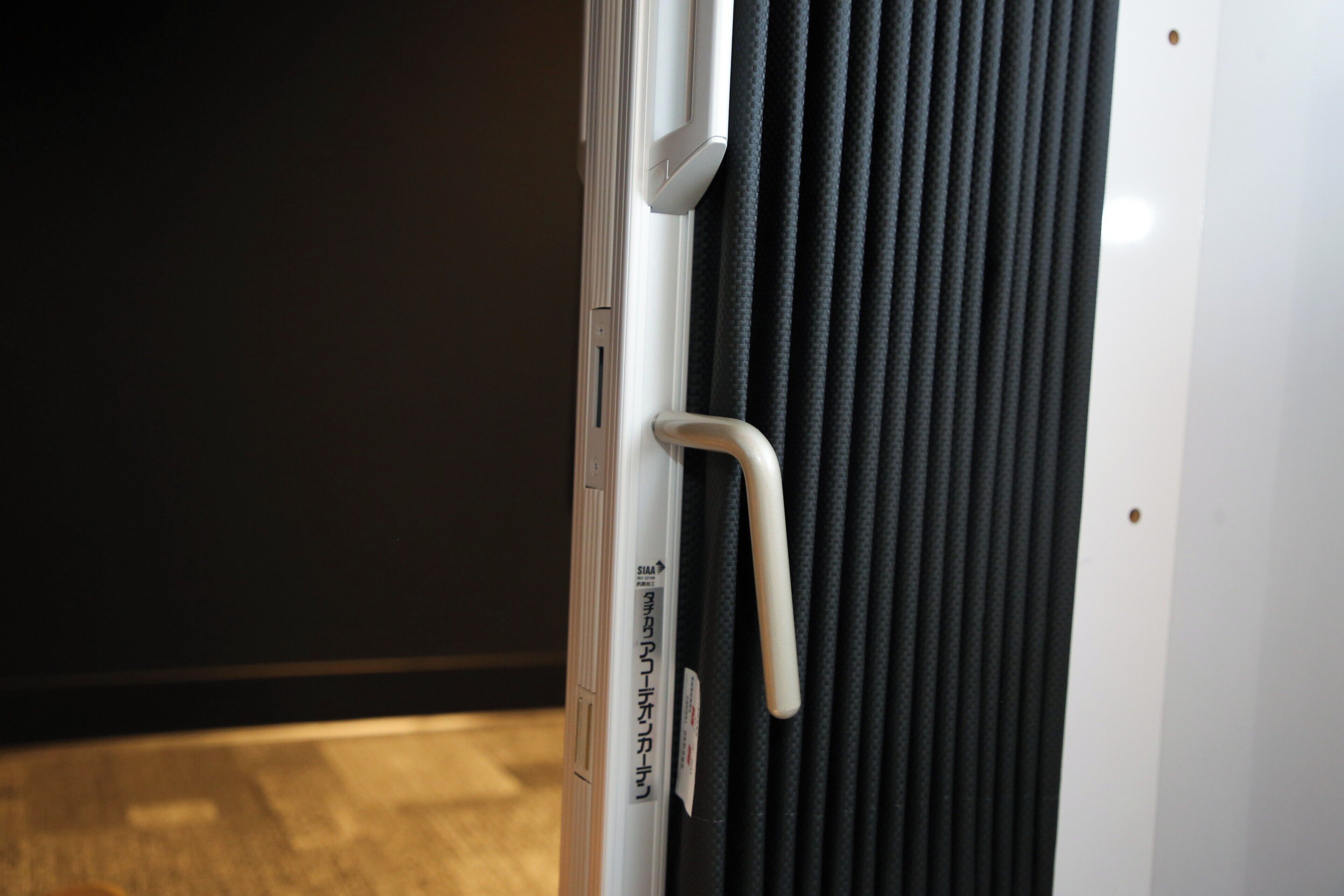 A close-up of a door handle and a vertical air vent.