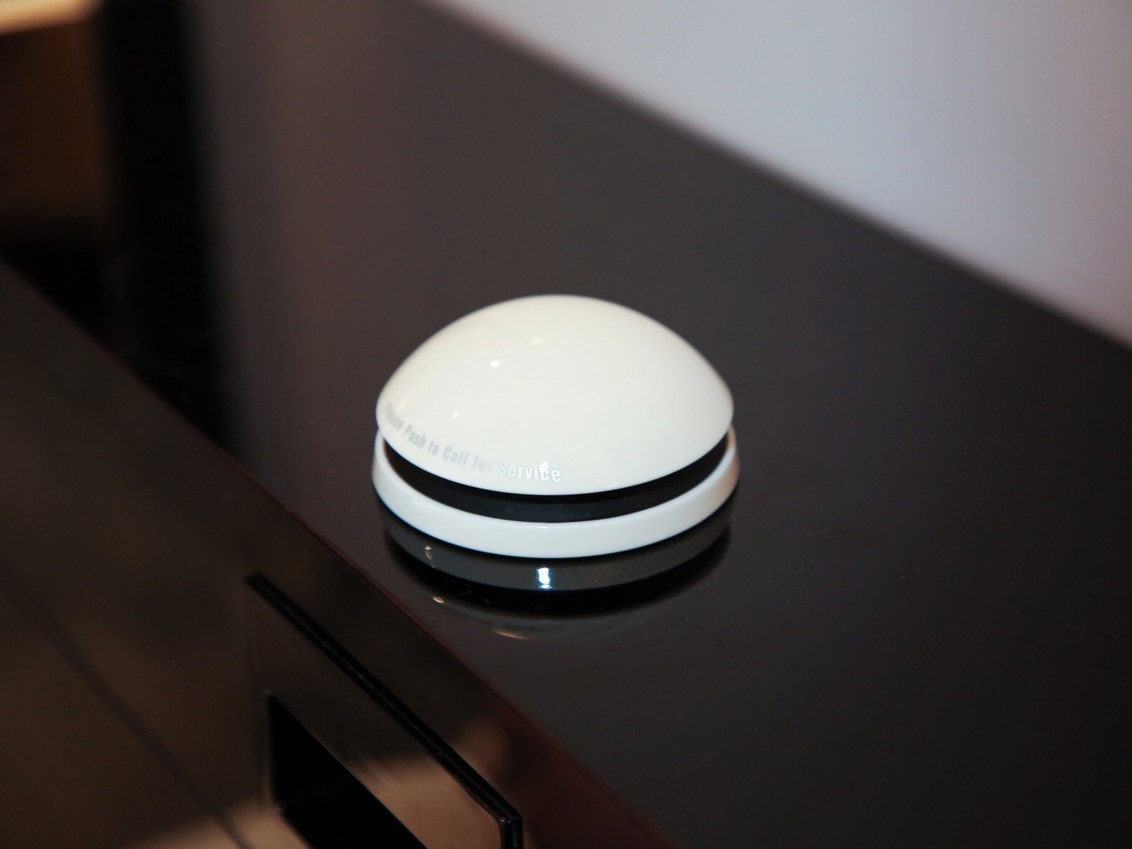 A white, circular device on a dark surface, possibly a control panel or interface.