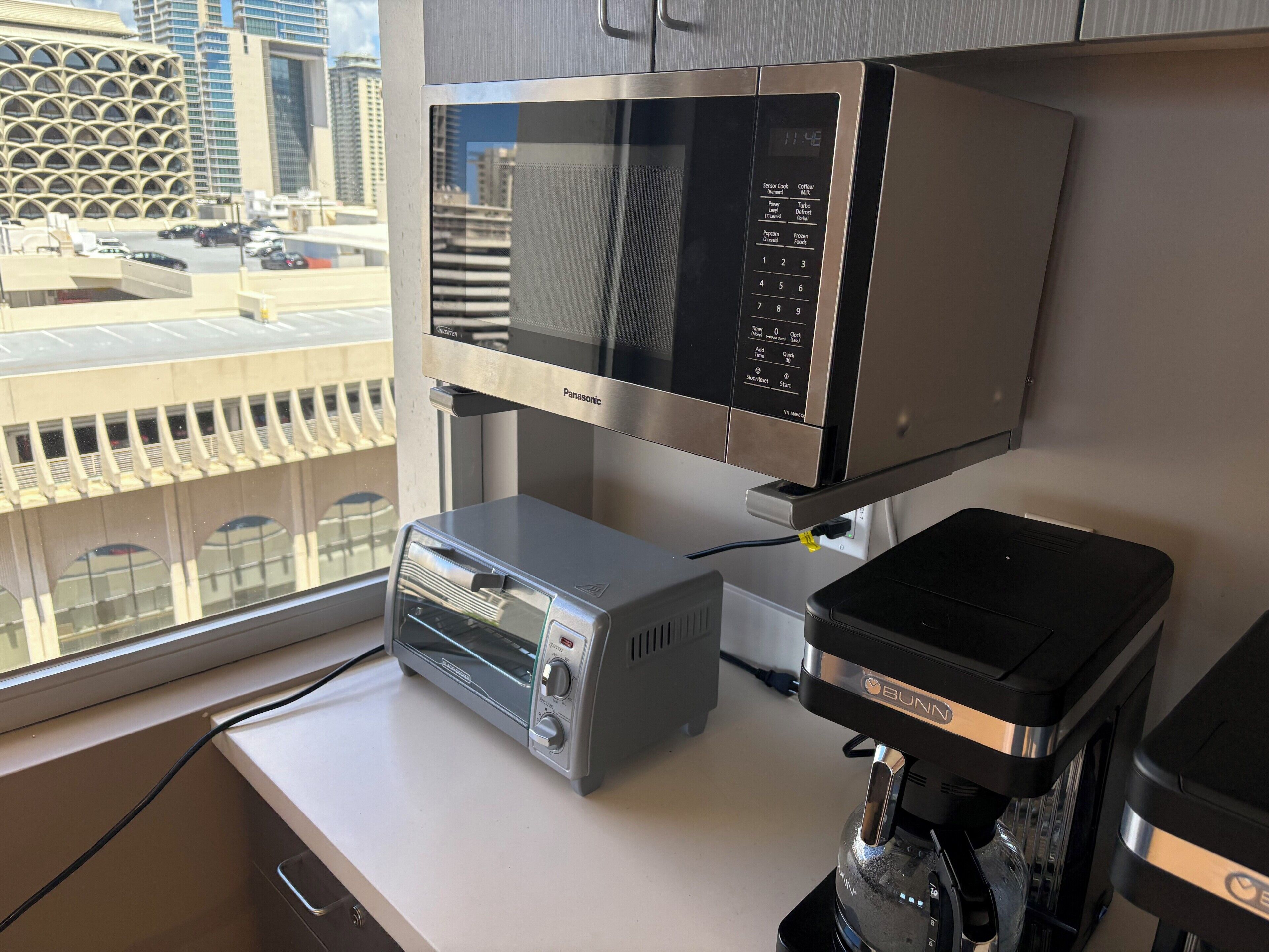 A kitchen with a microwave, toaster, and coffee maker.