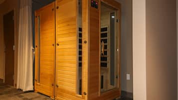 A wooden sauna with glass doors, a control panel, and a visible interior.