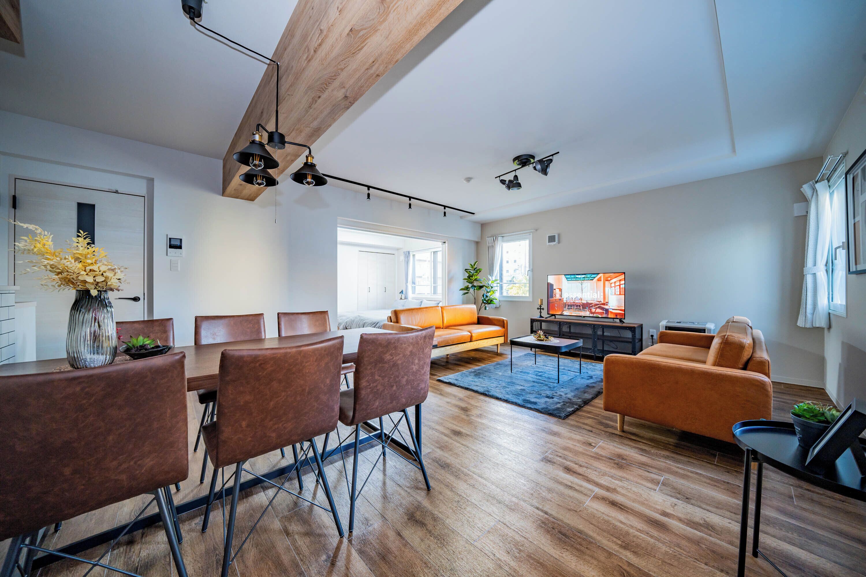 Un salon moderne avec un coin repas, un plancher en bois et un téléviseur.