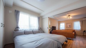 Un dormitorio amplio con una cama grande, un sofá y un televisor.