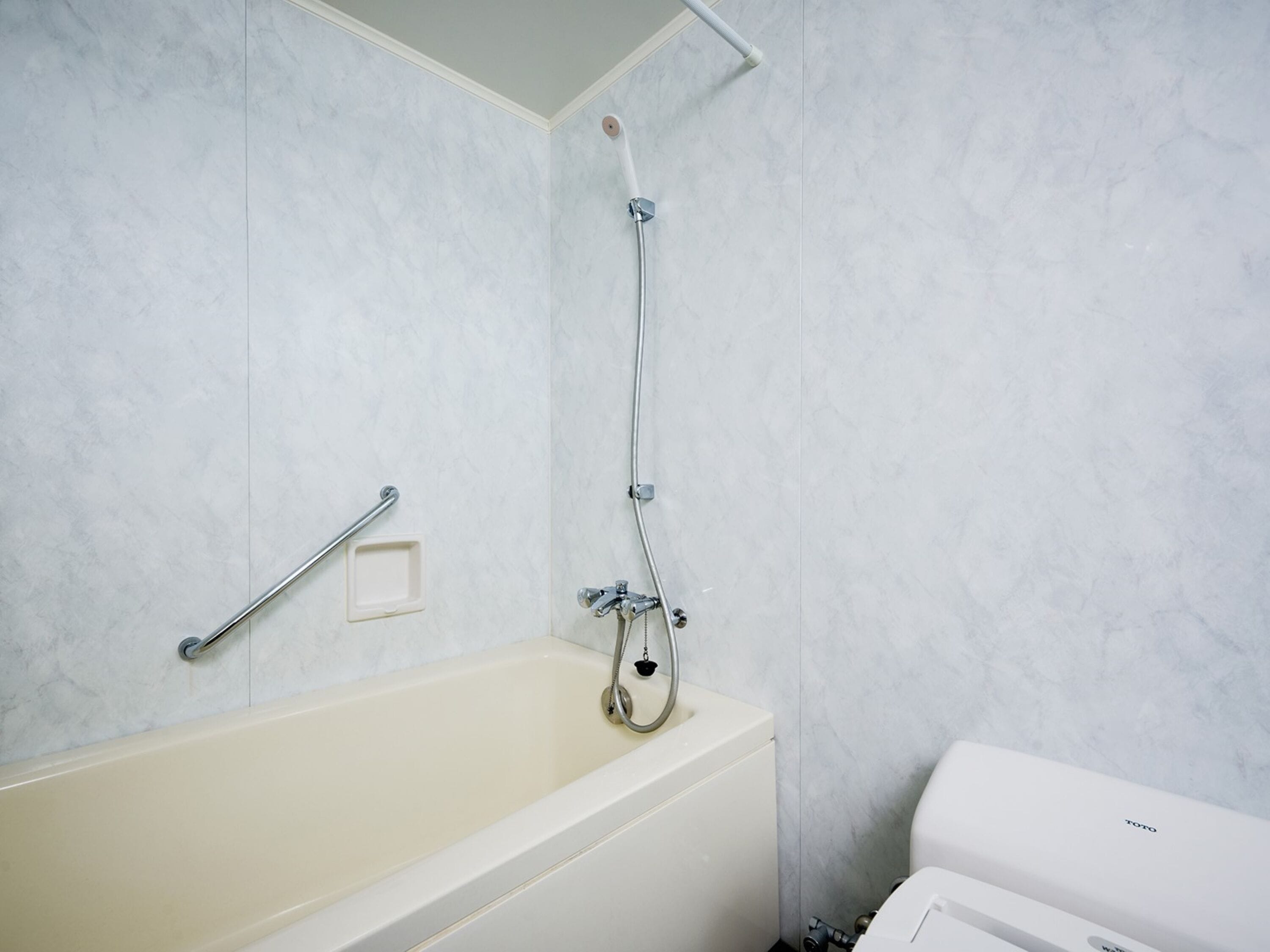 Combined shower/bathtub, hair dryer, slippers, towels