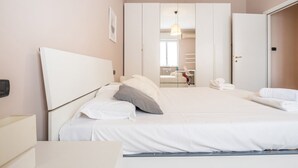 Une chambre d’hôtel comprenant un lit, une table de chevet, une armoire et un miroir.