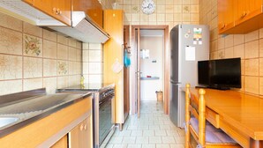 A kitchen with wooden cabinets, a stainless steel stove, a refrigerator, and a television. - Cozy apartment located on the fourth floor of a typical Milanese building with lift. The accommodation is located not far from the M3 subway stop Maciachini, the new Isola Garibaldi district and the Niguarda district. The accommodation is equipped with a (Milano)