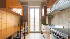 A kitchen with wooden cabinets, a stove, and a window. - Cozy apartment located on the fourth floor of a typical Milanese building with lift. The accommodation is located not far from the M3 subway stop Maciachini, the new Isola Garibaldi district and the Niguarda district. The accommodation is equipped with a (Milano)