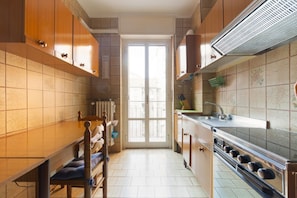 Una cocina con armarios de madera, una estufa y un ventanal.