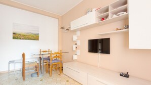 A modern room with a dining table, chairs, a TV, built-in shelves, and a painting on the wall. - Cozy apartment located on the fourth floor of a typical Milanese building with lift. The accommodation is located not far from the M3 subway stop Maciachini, the new Isola Garibaldi district and the Niguarda district. The accommodation is equipped with a (Milano)