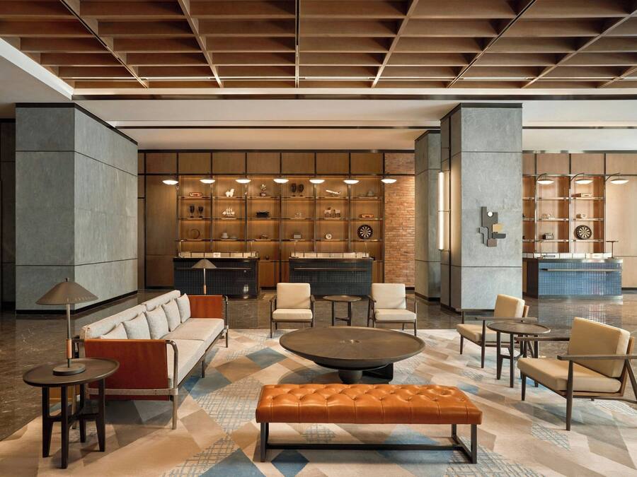 Un hall d’entrée moderne avec un espace salon, une cheminée et un bar.