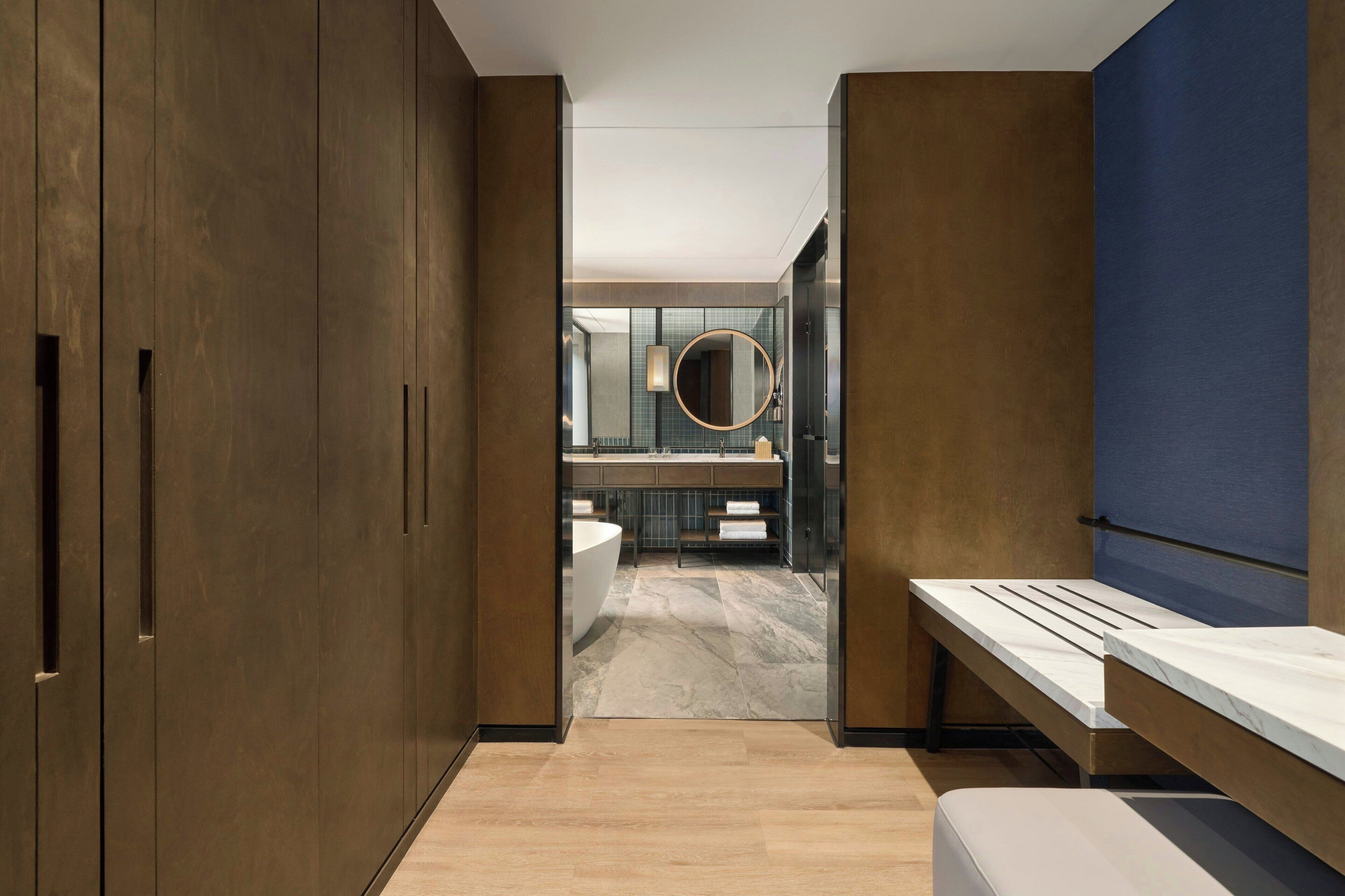 A modern bathroom with a large mirror, a bathtub, and a vanity with a sink.