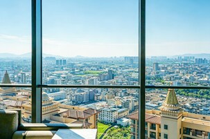 Um edifício alto com uma vista panorâmica do horizonte urbano através de grandes janelas.
