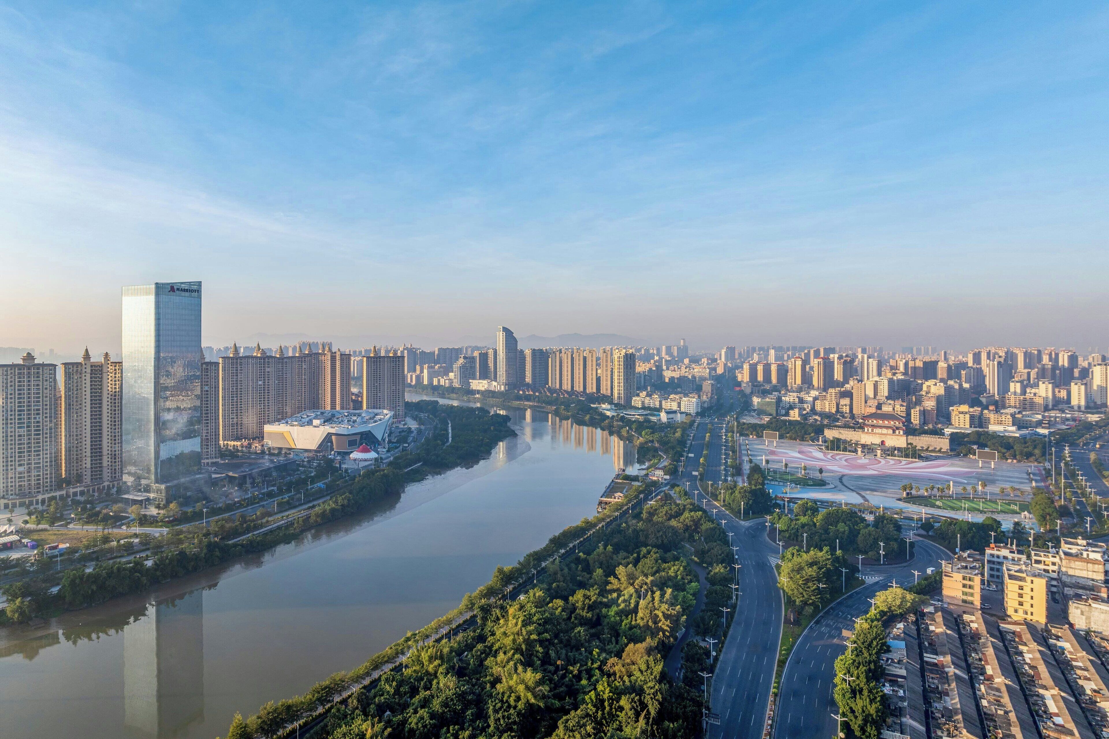 A cityscape with a river, high-rise buildings, and a modern skyscraper.