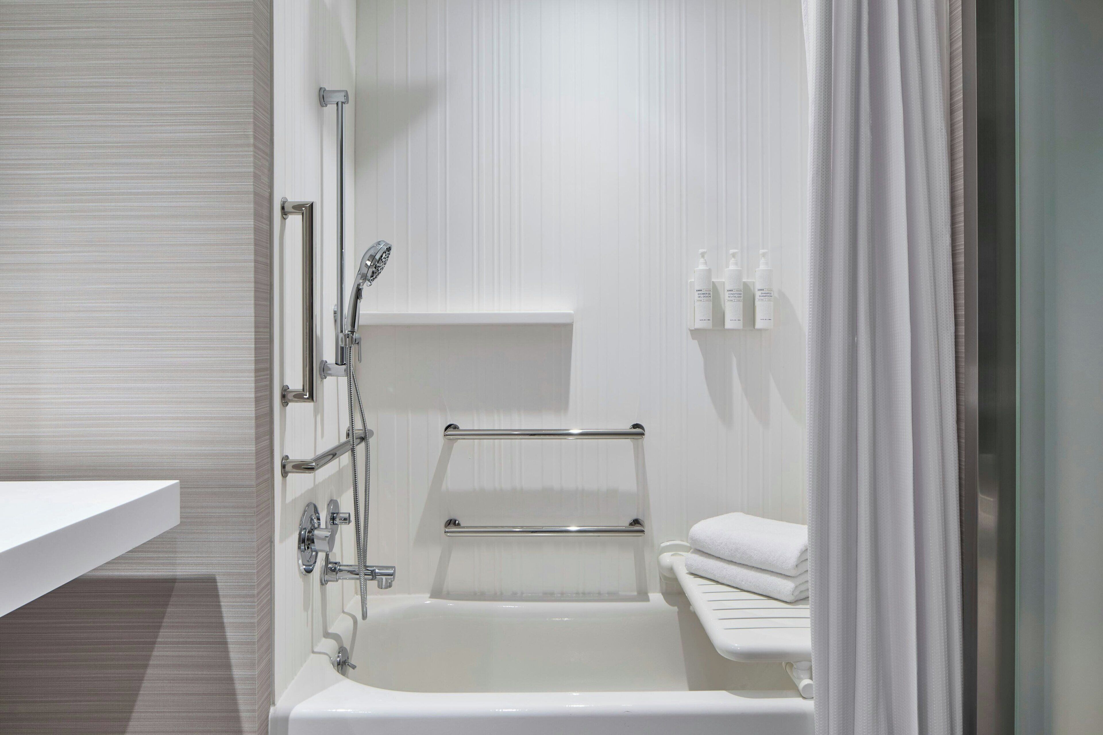 Une salle de bain moderne équipée d’une baignoire, d’une douche et d’un porte-serviettes.