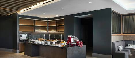 A modern kitchen with a central island, built-in appliances, and a seating area with a sofa and table.