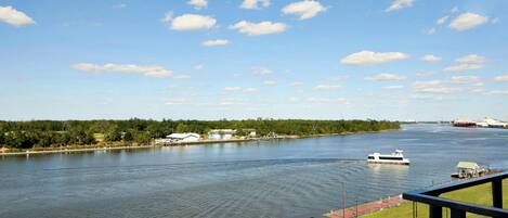 A river with a boat, a dock, and buildings along the shore.