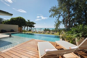 A wooden deck with lounge chairs and a swimming pool with a view of the ocean. - Moorea Beach Villas (Moorea-Maiao)