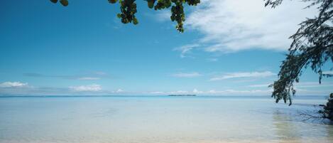 On the beach, white sand, sun-loungers, beach towels