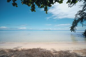 On the beach, white sand, sun loungers, beach towels