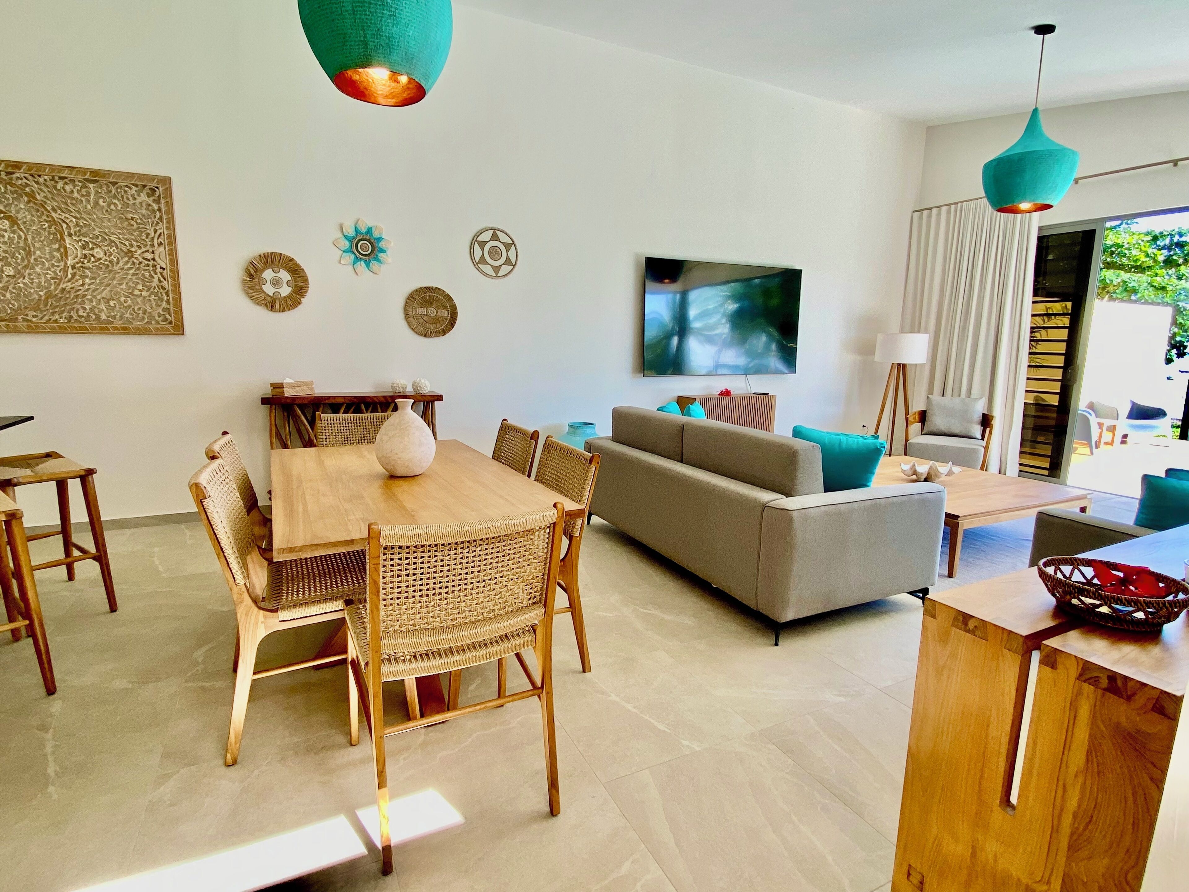 A modern living room with a dining area, a sofa, and a TV.