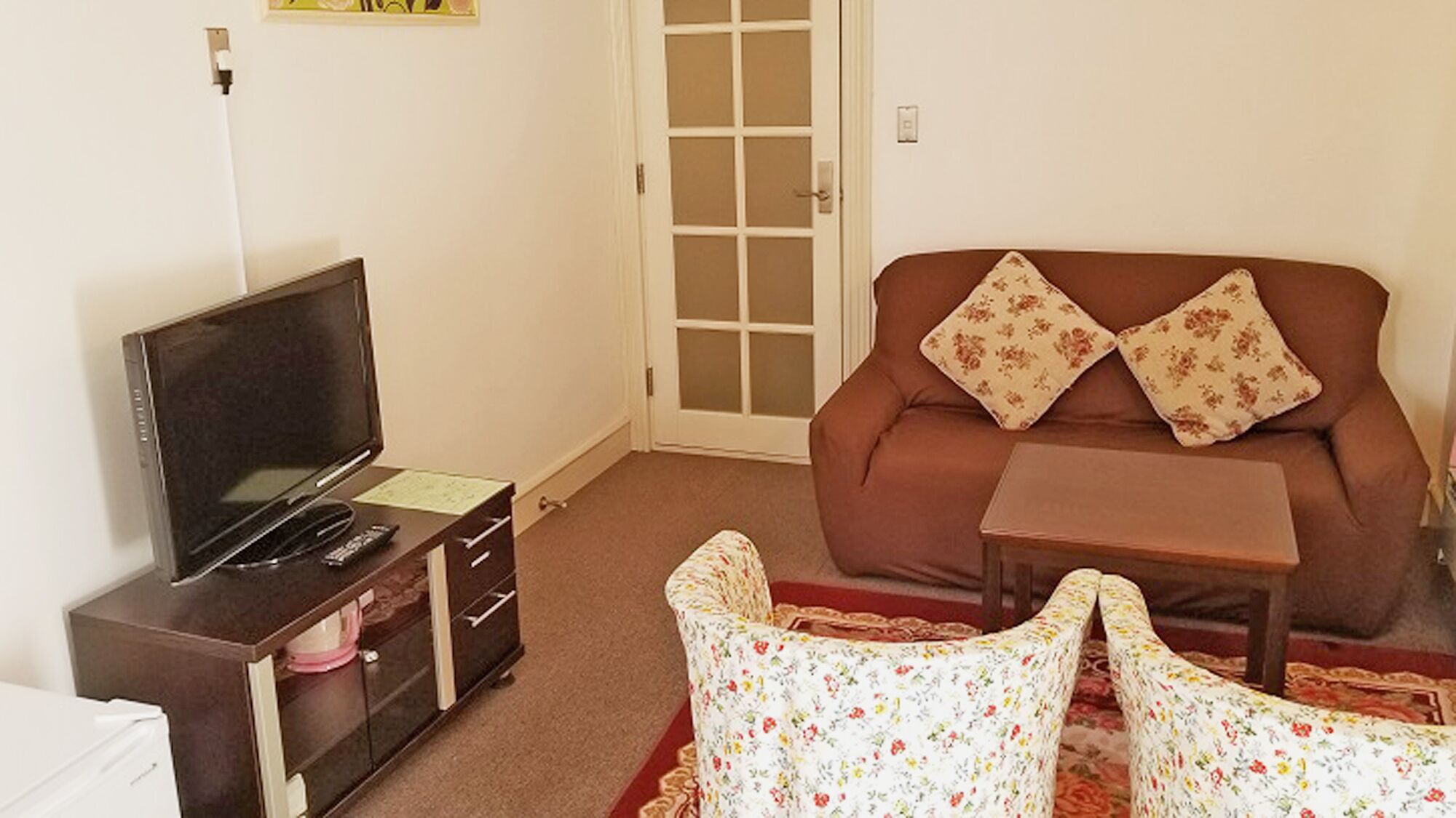 A living room with a television, sofa, and a small table.