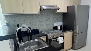 A kitchen with light wooden cabinets, a stainless steel sink, a gas stove, and a built-in oven.