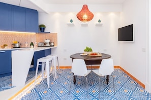A modern kitchen with blue cabinets, a white island, and a patterned floor. - Stylish & Elegant Flat with Terrace (Sorrento)