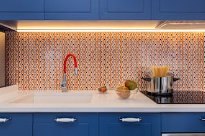 A modern kitchen with blue cabinets, a white countertop, and a patterned backsplash. - Stylish & Elegant Flat with Terrace (Sorrento)