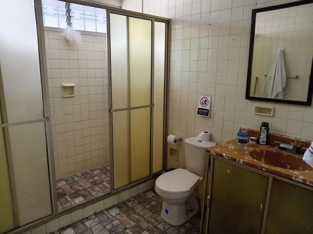Un baño con inodoro, lavabo y zona de ducha.