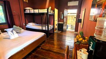 A room with a bunk bed, a desk with a water dispenser, and a window with curtains.