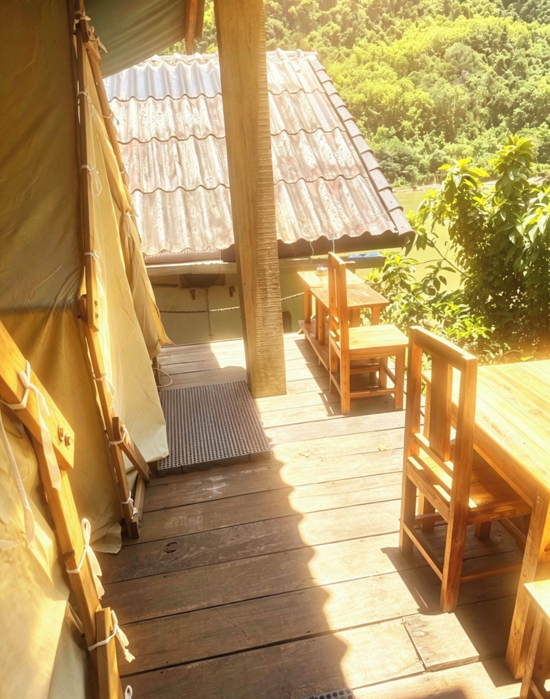 Eine Holzterrasse mit Tisch und Stühlen, ein überdachter Bereich mit Wellblechdach und Blick auf einen bewaldeten Hang.
