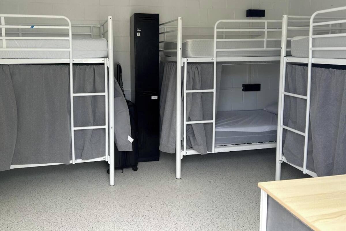 Un dormitorio con literas, un armario y un escritorio.