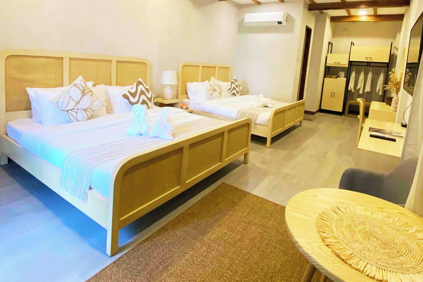 Une chambre d’hôtel avec deux lits, une petite table ronde et un coin cuisine.