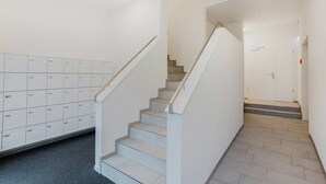 En trappa som leder upp till en liten plattform, och på vänster sida finns en rad förvaringslådor.