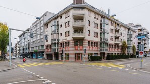 Un immeuble à plusieurs étages doté d’une architecture moderne, avec des balcons et de grandes fenêtres.