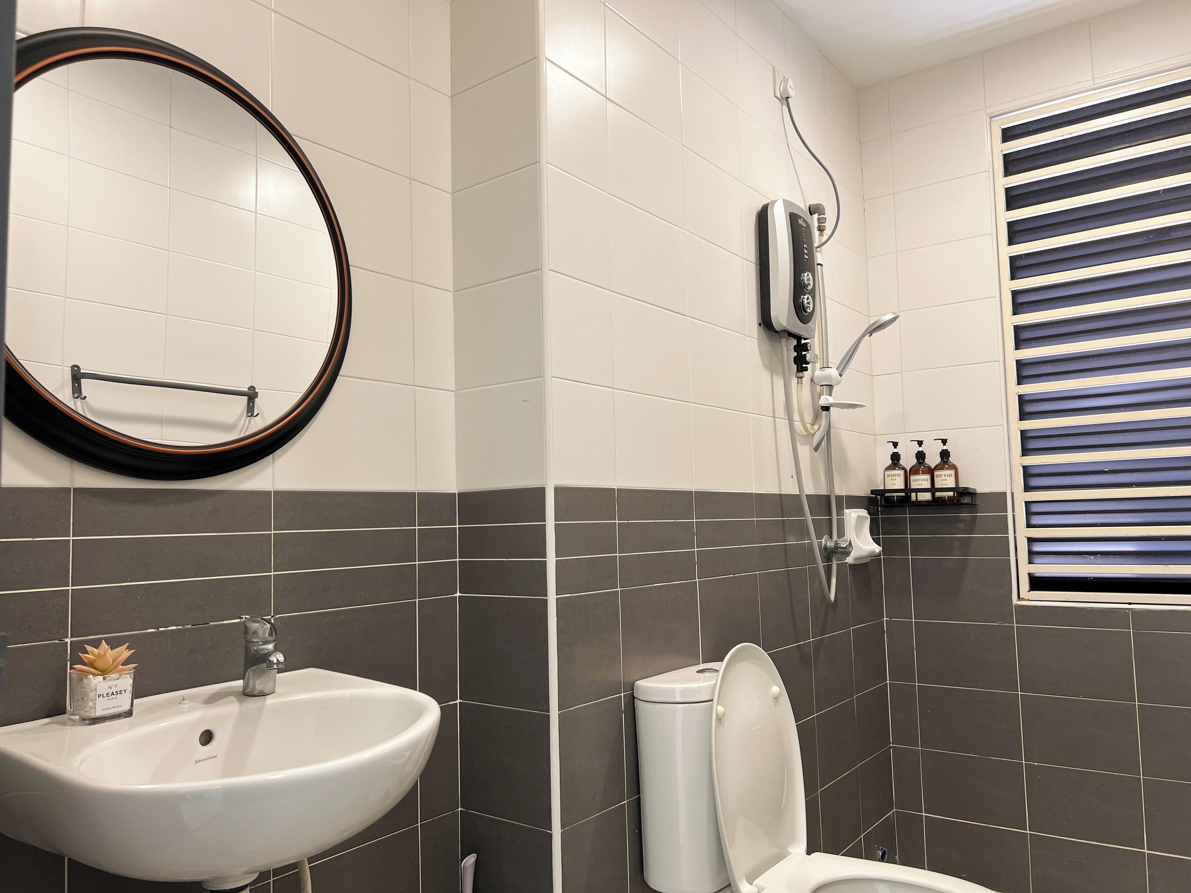 Un baño con lavabo blanco, inodoro, ducha y espejo.