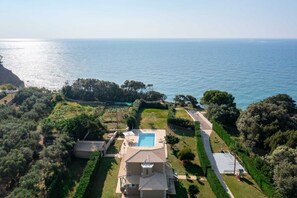 Une villa de style méditerranéen dotée d’une piscine, de jardins aménagés en terrasses et offrant une vue sur la mer.