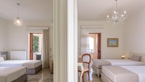 Hotellihuone, jossa on kaksi sänkyä, ruokailutila ja kattokruunu.